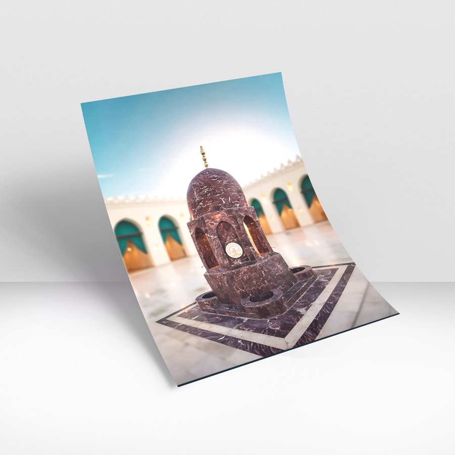 Marble domed pavilion structure centered in a mosque courtyard with arches and soft lighting in the background.